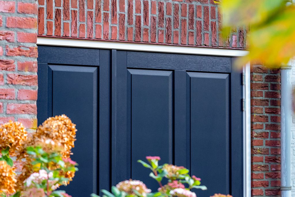 Houten garagedeur met sierlijsten