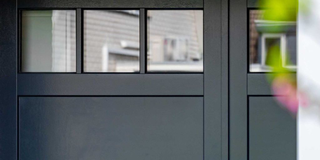Openslaande houten garagedeur met glaswerk boven